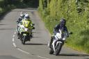 Bikers taking part in Safer Rider course under supervision of police motorcyclist