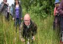 George Williams, front, taking a close look at some common spotted orchids, during one of the Norfolk Wildlife Trust walks around Beeston Common.