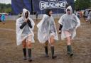 Festivalgoers cover up with plastic ponchos for the heavy rainfall at the Reading Festival at Little John’s Farm, Reading, Berkshire (Jeff Moore/PA)