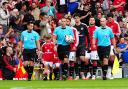 Manchester United are led out at Old Trafford by the two sons of PC Matthew Blades (David Davies/PA).