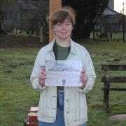Millie Sturman pictured with her winning design in front of the sign.