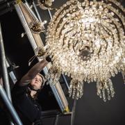 Extensive care is taken to ensure the safety of the chandelier while it is being cleaned.