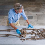 English Heritage head curator of collections Kevin Booth lays out the skeleton of ‘Conquest Man’ at St Peter’s Church in Barton-upon-Humber, North Lincolnshire, where he was originally buried in c1079 (Dominic Lipinski/English Heritage/PA)