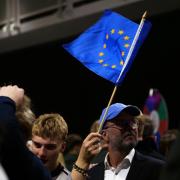 A supporter waves a European Union flag (Marco Di Marco/AP)