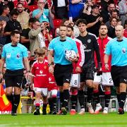 Manchester United are led out at Old Trafford by the two sons of PC Matthew Blades (David Davies/PA).